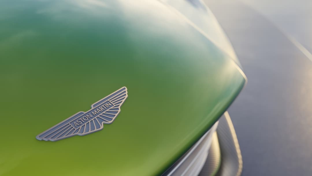 Logomarca da Aston Martin sobre capô de carro esportivo