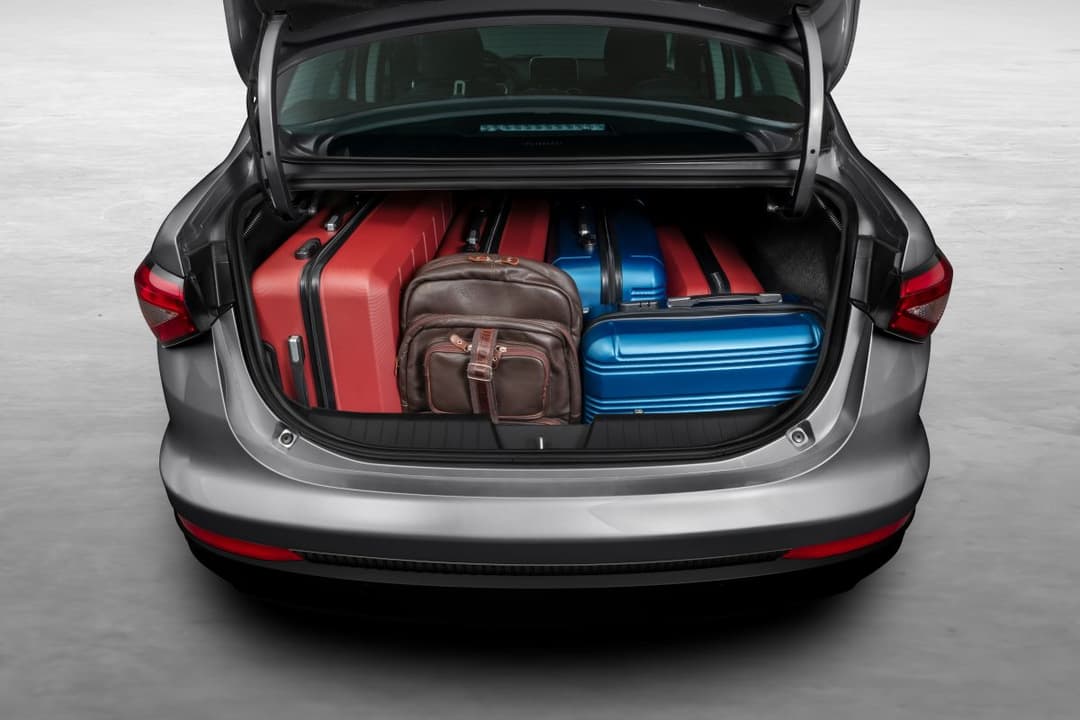 Fiat Cronos Precision com o porta-malas aberto e malas dentro do compartimento